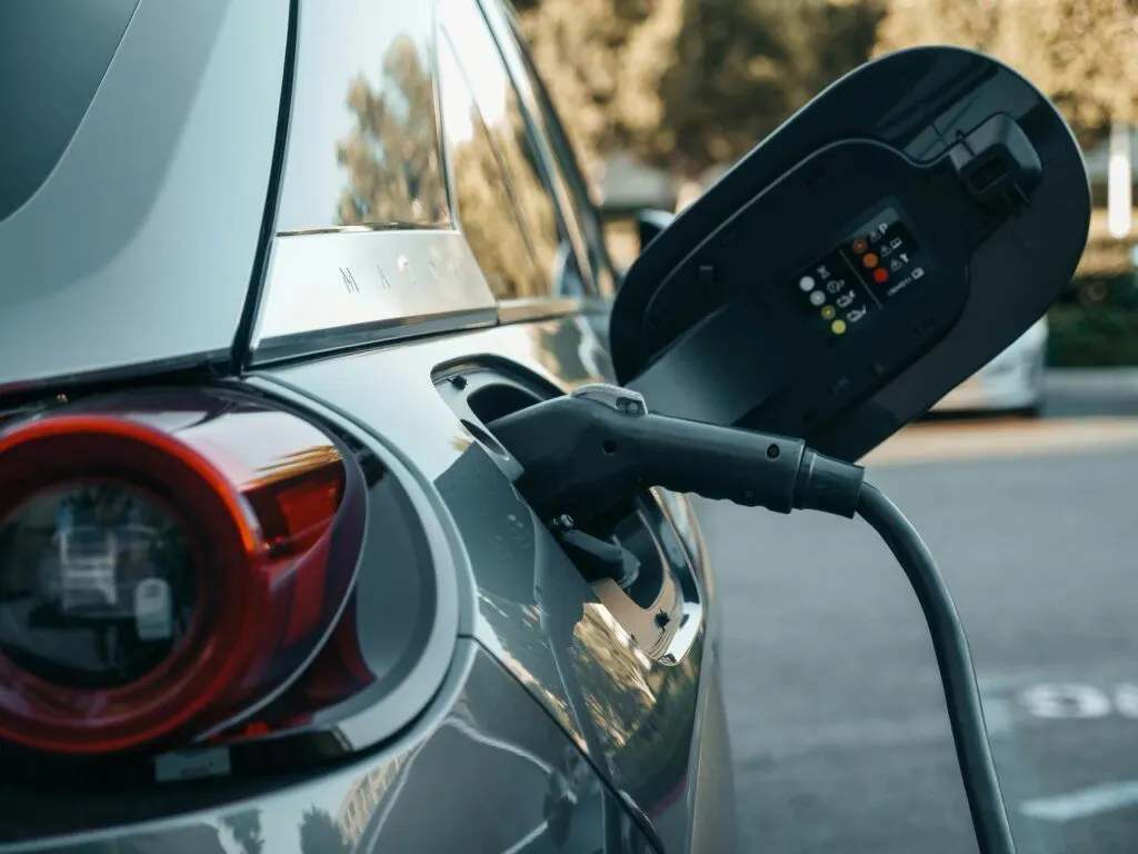 Conector de carga enchufado en la toma de un coche eléctrico